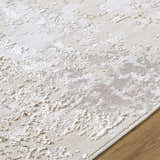 Close-up of the Junko Area Rug, a contemporary rug in beige, cream, and tan with a textured, abstract pattern. Texture