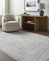 Living room scene with a light wood console table, swivel chair, and Adilet Blue Washable Area Rug. Roomscene-Rectangle