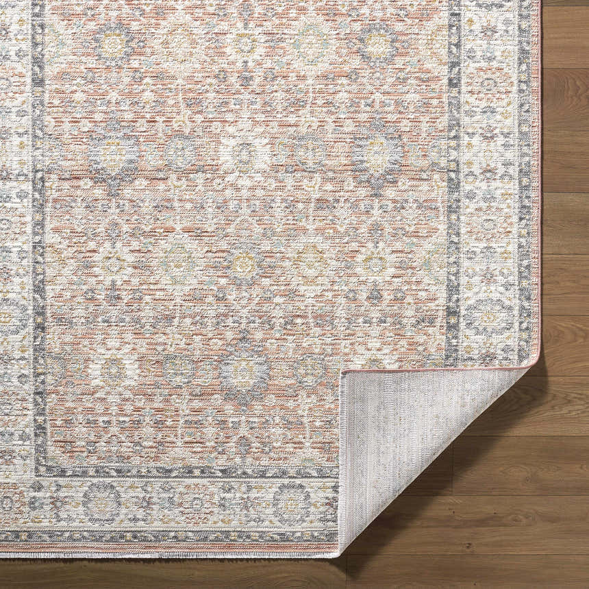 Close-up of the Adilet Dark Pink Washable Area Rug showing its traditional floral pattern, pink hues, and machine-woven texture. Fold