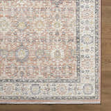 Close-up of the Adilet Dark Pink Washable Area Rug showing its traditional floral pattern, soft pink hues, and textured weave. Corner