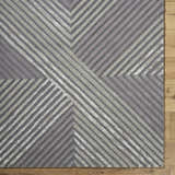 Close up of the hand tufted Juan Area Rug featuring a contemporary geometric stripe pattern in beige, gray, and taupe. Corner