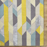 Close-up of the hand-tufted Zoie Area Rug. Modern geometric design in camel, gray, lambswool, and saffron hues. Wool texture. Corner