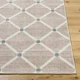 Close up of the Alpana Washable Wool Area Rug. Beige rug with ivory diamond pattern and slate gray accents on wood floor. Front