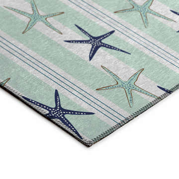 Close-up of Dalyn Seabreeze SZ12 Mist Washable Area Rug. Coastal style with blue starfish on a striped muted sage and off-white background.