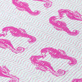 Close-up of Dalyn Seabreeze SZ15 Flamingo rug. Fuchsia seahorse pattern on a silver gray wavy striped background.
