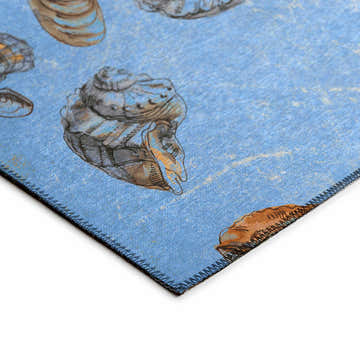 Close-up of the denim blue Dalyn Seabreeze area rug with a seashell pattern. Coastal style.