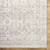 Close-up of the Tyren Area Rug featuring a traditional cream, tan, and slate blue floral pattern on a textured polyester weave. Corner