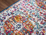 Close-up of the Tigril Blue & Orange 2304 Area Rug. Features a bohemian floral pattern in ivory, navy, red, and orange. Texture
