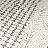 Close-up of the Tideswell Scandi Boho Wool Carpet showing its beige wool texture and black geometric and chevron patterns. Texture