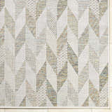 Close-up of the Andrea Ivory Area Rug featuring a geometric pattern in ivory, sage, sandstone, sky blue, and taupe. Corner