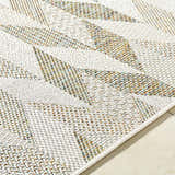 Close up of Andrea Ivory Area Rug showing the woven texture and geometric pattern in ivory, sage, sandstone and sky blue. Texture