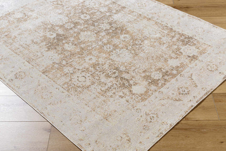 Close-up of the Aniyah Washable Area Rug. Colors are ash, pearl, prairie dust, and tan with a traditional pattern. Corner