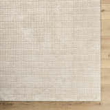 Close-up of the Cascade Machine Woven PNW Home x LIVABLISS PNWCS-2306 Area Rug. Beige rug with a subtle, textured grid pattern. Corner