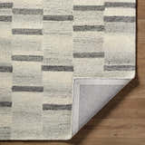 Close up of the Timmy Area Rug showing light silver and slate blue stripes on a textured wool rug. Fold