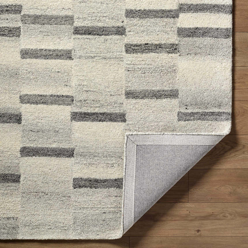 Close up of the Timmy Area Rug showing light silver and slate blue stripes on a textured wool rug. Fold
