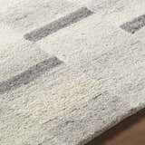 Close-up of the hand-tufted Timmy Area Rug. Light silver wool rug with a contemporary slate blue and sage block pattern. Texture