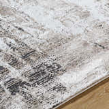 Close up of the Taszi Luxe Thick Area Rug showing black, ivory, peach, and tan colors and a contemporary design. Texture