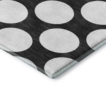 Close-up of Dalyn Luxury The Reserve TR13 Black Washable Area Rug with a large off-white polka dot geometric pattern.