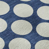 Close-up of Dalyn Luxury The Reserve TR13 Navy Washable Area Rug. Features a navy background with large white polka dots.