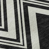 Close-up of the Dalyn Luxury The Reserve TR17 Black Washable Area Rug, featuring a bold black and off-white geometric pattern.