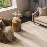 Living room scene with a Teige Light Silver Area Rug, tan sofa, and leather chair. Neutral colors create a cozy, modern feel. Roomscene-Rectangle