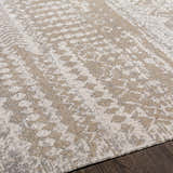 Close-up of the Tupsan Washable Area Rug. Cream, light beige, and gray rug with a subtle, contemporary pattern. Texture