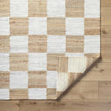 Close-up of the Kamey Handmade Becki Owens x LIVABLISS BOKY-2302 Area Rug. Jute rug features a light brown and white checkerboard pattern. Fold