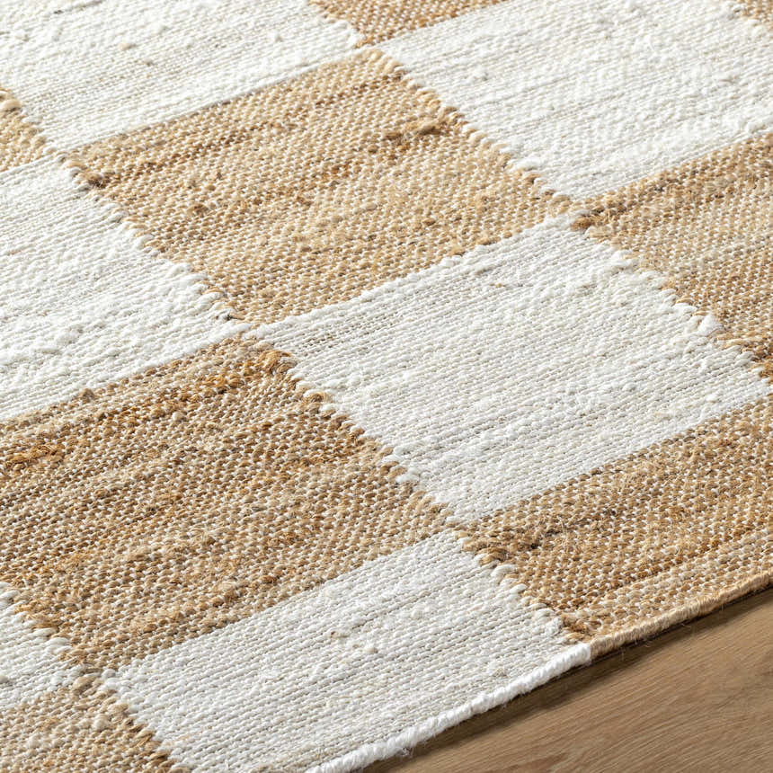 Close up of Kamey Handmade Becki Owens x LIVABLISS rug showing a light brown and white woven checkerboard pattern. Texture