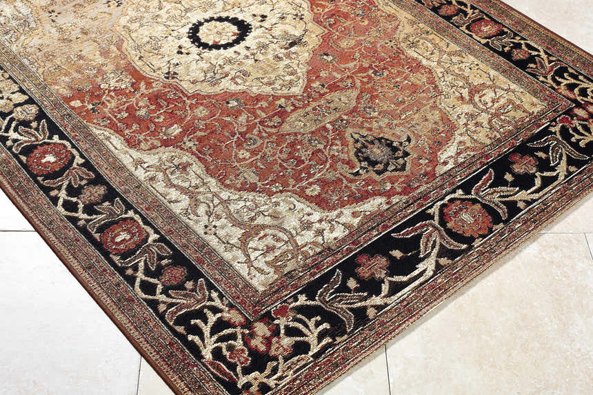 Close-up of the Vonda Area Rug. Traditional design in charcoal, crimson, gold, and ivory. Floral border detail. Corner