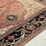 Close-up of the Vonda Area Rug. Traditional design in charcoal, crimson, gold, and ivory. Machine woven texture. Texture