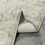 Close-up of the Fetscher II Vintage Medallion Area Rug showing beige, light brown, and olive tones. Machine-woven texture detail. Fold