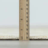 Close-up of Fetscher II Vintage Medallion Area Rug pile height, showing beige and light brown tones with a ruler. Pile