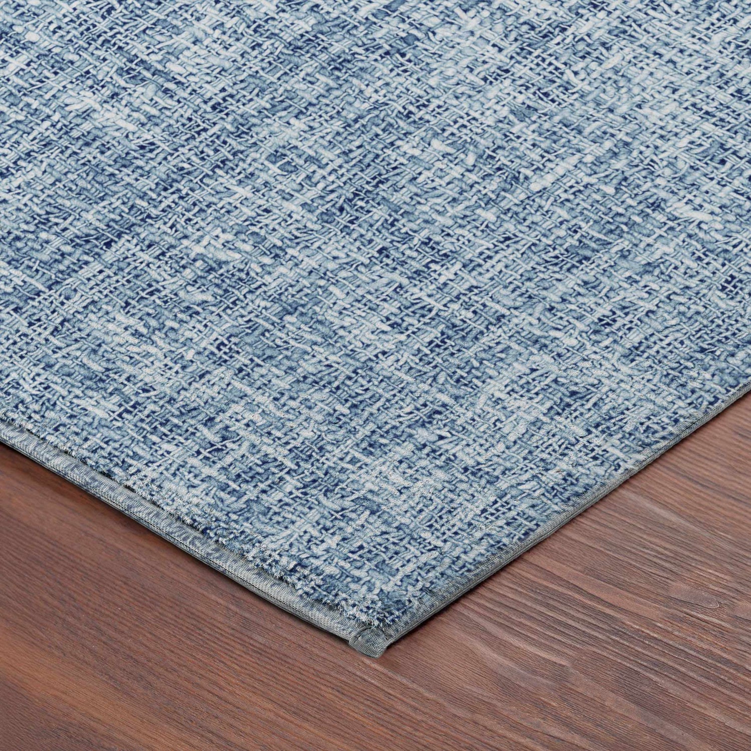 Close-up of the Dalyn Luxury Voyage VY1 Denim Washable Area Rug showing its denim blue woven texture and pattern.