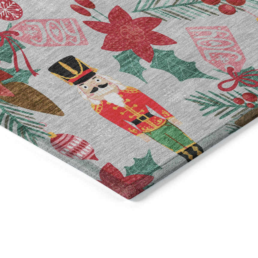 Close-up of the Dalyn Wonderland WN30 Silver Washable Area Rug. Features nutcrackers, ornaments, and holiday foliage on a gray background.