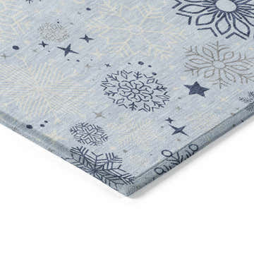 Close-up of Dalyn Wonderland WN31 Sky Washable Area Rug. Features snowflake and star pattern in sky blue, navy, and chestnut.