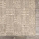 Close-up of the hand-woven Wolseth Area Rug, off-white color, with a subtle geometric pattern and textured wool and polyester blend. Swatch