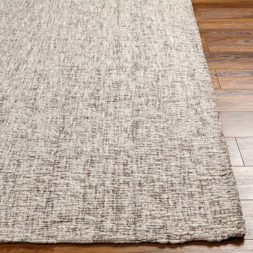 Close-up of the hand-loomed Westoning Area Rug. Features a textured weave in off-white, light gray, charcoal, and black. Front