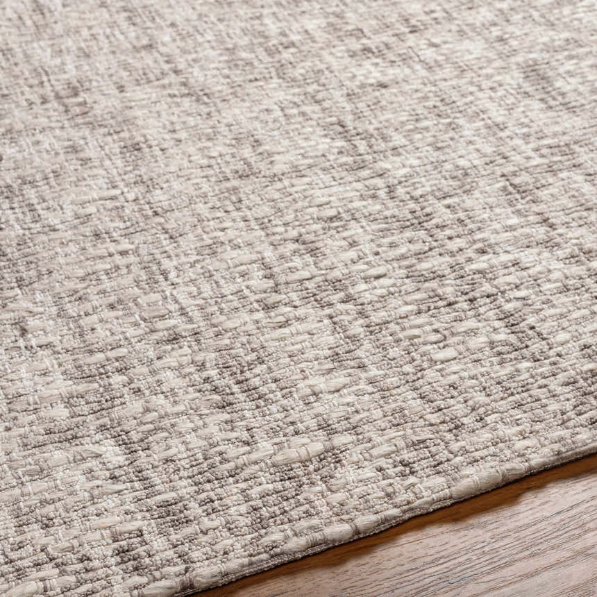 Close-up of the hand-loomed Westoning Area Rug. Features a textured weave in light gray, charcoal, and off-white. Texture