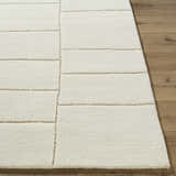 Close-up of the hand-tufted Xylia Beige Area Rug. Light silver and off-white wool rug with a contemporary block pattern. Front