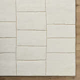 Close-up of the hand-tufted Xylia Beige Area Rug. Off-white wool with a contemporary rectangular block pattern. Corner