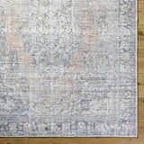 Close-up of the gray, light silver, and prairie dust Yachi Washable Area Rug showing its farmhouse traditional pattern. Swatch