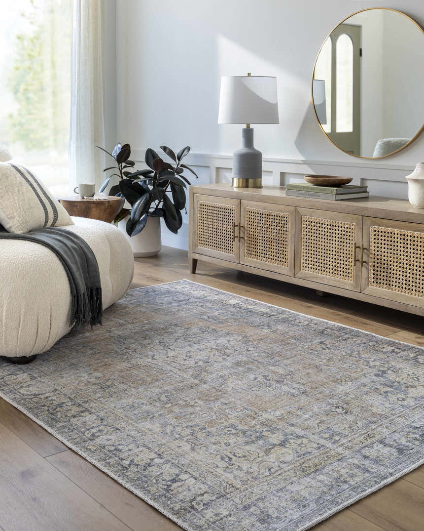 Living room scene with a gray Yachi Washable Area Rug, cream sofa, wood cabinet, round gold mirror, and hardwood floors. Roomscene-Rectangle