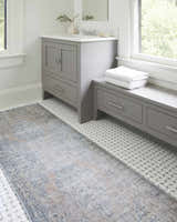 Bathroom scene with gray vanity and Yachi Washable Area Rug in gray, silver and prairie dust colors on white tile floor. Roomscene-Runner