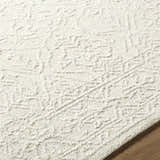 Close-up of the Yadid Cream Wool Area Rug showing its ash and pearl tones and hand-tufted texture. Texture