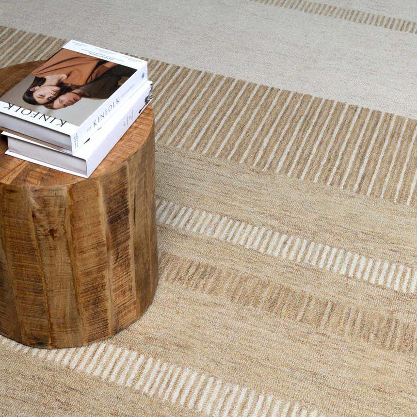 Close-up of the Yoyko Area Rug in ash, pearl, and tan with a linear striped pattern and a textured, hand-tufted wool construction. Styleshot