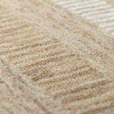 Close-up of the tan Yoyko Area Rug. Hand-tufted wool rug with a subtle geometric pattern. Soft texture. Texture