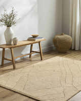 Neutral room scene with a beige Addien Area Rug, light wood floors, bench, and decorative vases. Roomscene-Rectangle