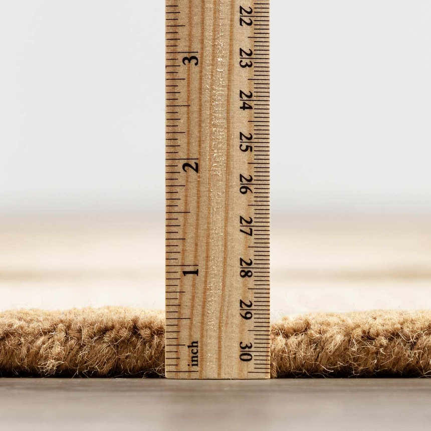 Close up of the Aradia Tan Area Rug showing its pile height with a ruler. Pile