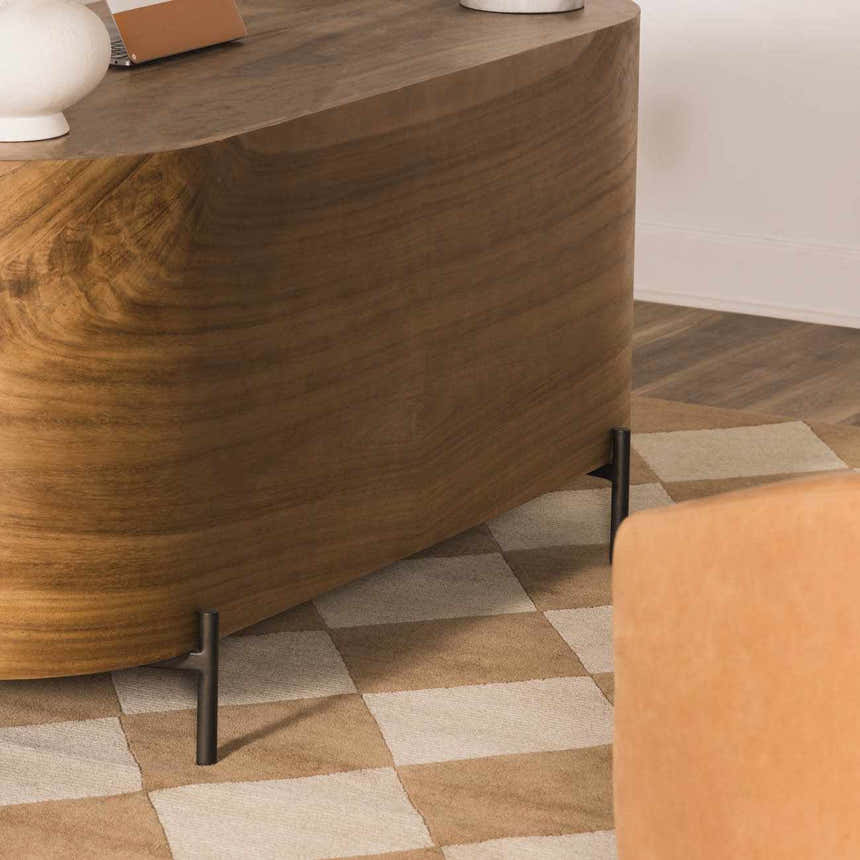 Close-up of the Aradia Tan Area Rug featuring a checkerboard pattern in tan and cream under a wood table. Roomscene-Rectangle