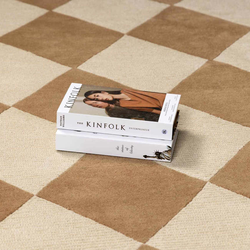Close-up of the Aradia Tan Area Rug showing a tan and cream checkerboard pattern and wool texture. Styleshot